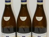 trois bouteilles de vin posées sur une table, l'une à côté de l'autre