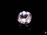 a close up of a pink diamond on a black surface