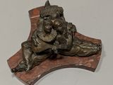a bronze statue of a man and a dog on a wooden plaque