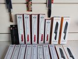 Des boîtes de couteaux sont empilées les unes sur les autres sur une table