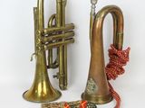 two brass trumpets and a red ribbon on a white background