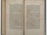 an open book on a white surface with a black border