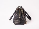 black leather handbag with gold zippers on a white background