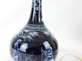 a blue and white vase with an umbrella on a table