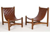 une paire de fauteuils de salon en cuir marron avec des pieds en bois