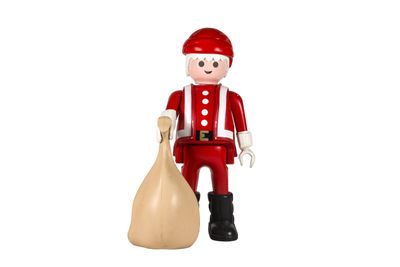 un petit soldat en jouet tenant un sac de cadeaux, sur fond blanc