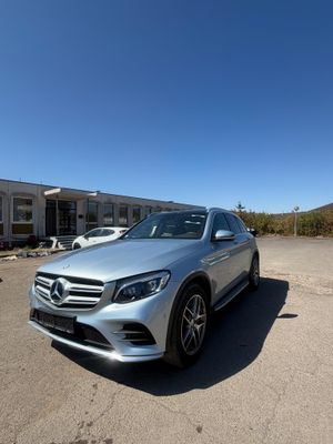 un SUV Mercedes argenté garé devant un immeuble