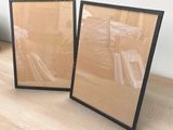 two picture frames sitting on a wooden floor next to each other