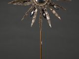 une sculpture en argent et en or représentant un tournesol, posée sur un socle en bois