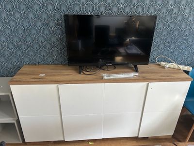 a flat screen tv sitting on top of a wooden entertainment center