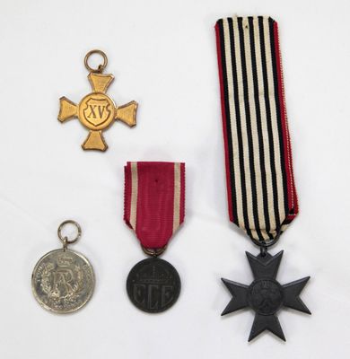 trois médailles et une médaille sont posées sur une surface blanche