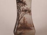 un vase en verre orné d'une peinture représentant des arbres