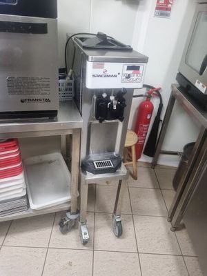 une cafetière posée sur un support métallique dans une cuisine