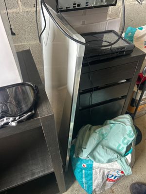 a microwave sitting on top of a cabinet next to a trash can