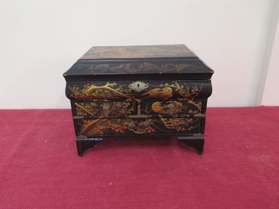 a black and gold chest sitting on top of a red carpet