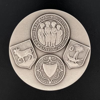 un gros plan d'une médaille posée sur une surface noire, avec un fond noir