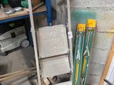 Plusieurs paires de skis et de bâtons de ski sont empilés sur une étagère dans un garage.