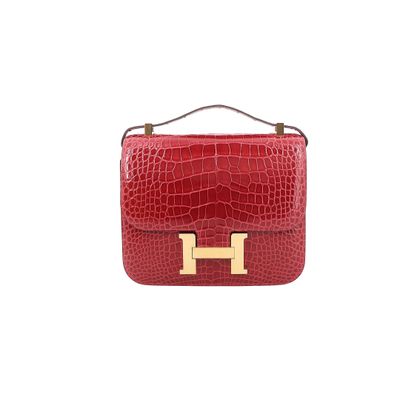 un sac à main rouge avec des finitions dorées sur la poignée