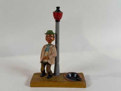 a figurine of a man sitting on a lamp post