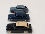several toy cars are lined up on a white surface