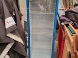 a blue refrigerator that is sitting in the middle of a pile of clothes