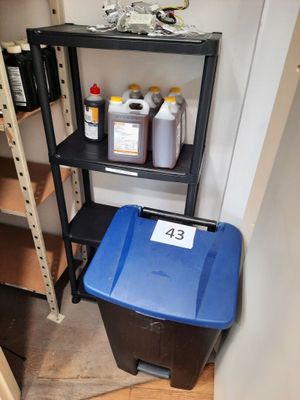 a blue trash can and a black trash can in the corner of a room