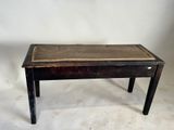 une vieille table en bois avec un plateau en cuir, sur fond blanc