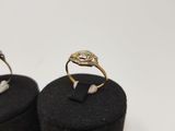 pair of gold and diamond rings on black velvet boxes on white background