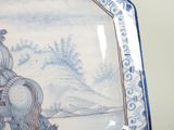 a blue and white plate with a picture of a man riding a horse