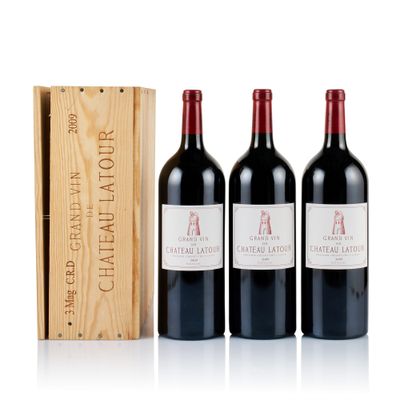 three bottles of red wine and a wooden box on a white surface