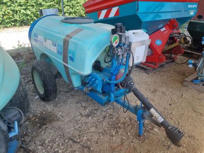 un tracteur bleu auquel est attelée une remorque bleue