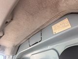 une photo d'une voiture sur laquelle est accrochée une pancarte à l'arrière
