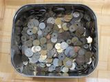 beaucoup de pièces de monnaie dans un récipient en métal posé par terre