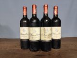 three bottles of red wine sitting on top of a wooden table