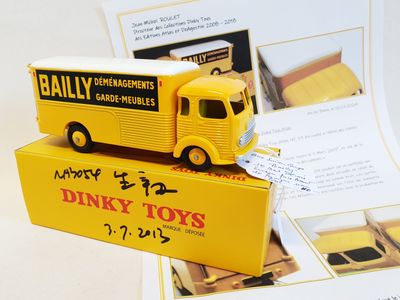 a yellow toy truck that is sitting on top of a box