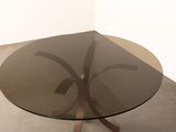 a glass table with a metal base in a room