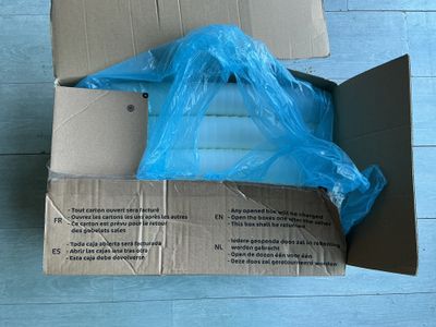 une boîte en carton contenant un sac en plastique bleu