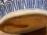 a blue and white vase sitting on a wooden table