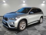 a silver bmw suv parked in a garage with a checkered floor