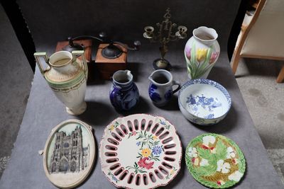 une table sur laquelle sont posées de nombreuses assiettes et vases