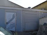 une voiture garée devant un immeuble dont la porte est ouverte