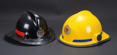 deux casques de pompier posés l'un à côté de l'autre sur une table