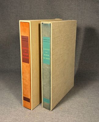 two books sitting on top of each other on a gray surface