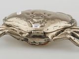 an image of a silver crab shaped object on a white surface