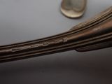 a spoon and a spoon rest on a table next to a coin