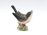 a small figurine of a bird sitting on top of a table