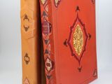un livre orange et un livre jaune posés l'un à côté de l'autre sur une surface blanche