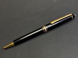 un stylo noir et doré posé sur une table