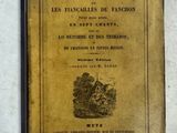 un vieux livre posé sur une table à côté d'un mur blanc