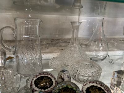 une étagère en verre sur laquelle sont posés de nombreux objets en verre